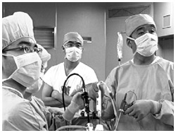 写真：モニター画面に映し出された様子を見ながら手術する医師たち