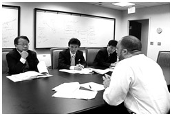 写真：補完代替医療の視察に訪れた米国NIHでホワイト博士（右端）と話し合う伊藤さん（左端）