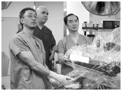 写真：手術用ロボットのダヴィンチを使ってトレーニング中の秦野さん（右）
