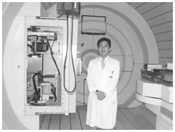 写真:陽子線治療装置の前で