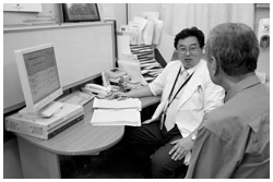 写真：患者さんに説明する山口さん