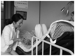 写真：真弓さんを訪問看護する看護師の堀加代子さん