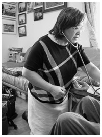 写真：寛太さんの血圧を測る関本クリニックの関本雅子さん
