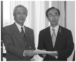 写真：渡辺孝男厚生労働省副大臣に要望書を提出する「日本がん楽会」代表の中原武志さん（左）