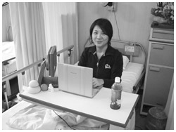 写真：手術の数日後、ベッドの上で連載記事の執筆にあたる山崎さん
