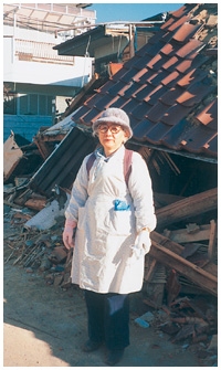 写真：震災直後に全壊した自宅の前で