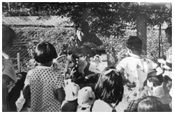 写真:1973年、東中野駅前の公園で紙芝居を上演する若き日の源さん