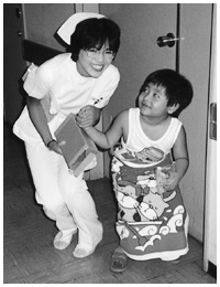 写真：紹大学病院の看護師時代。入院中の子供とたわむれる