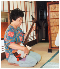 写真:三味線をひく今井さん